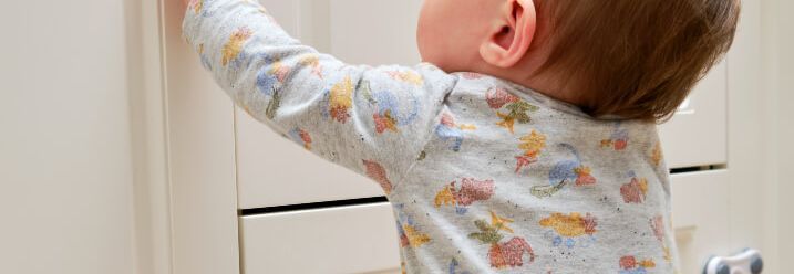 Kleinkind öffnet Schranktür